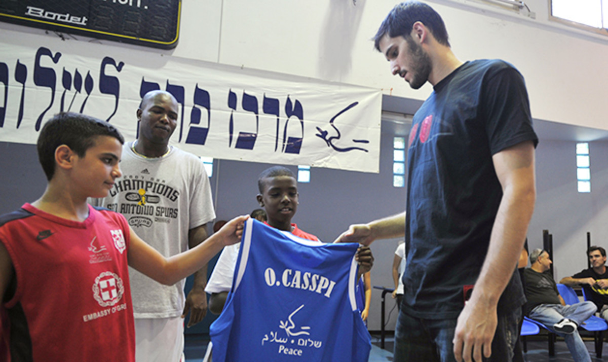 Omri Casspi, with a young Israeli (left) and Palestinian (right) in 2010, has given back to his home country.
