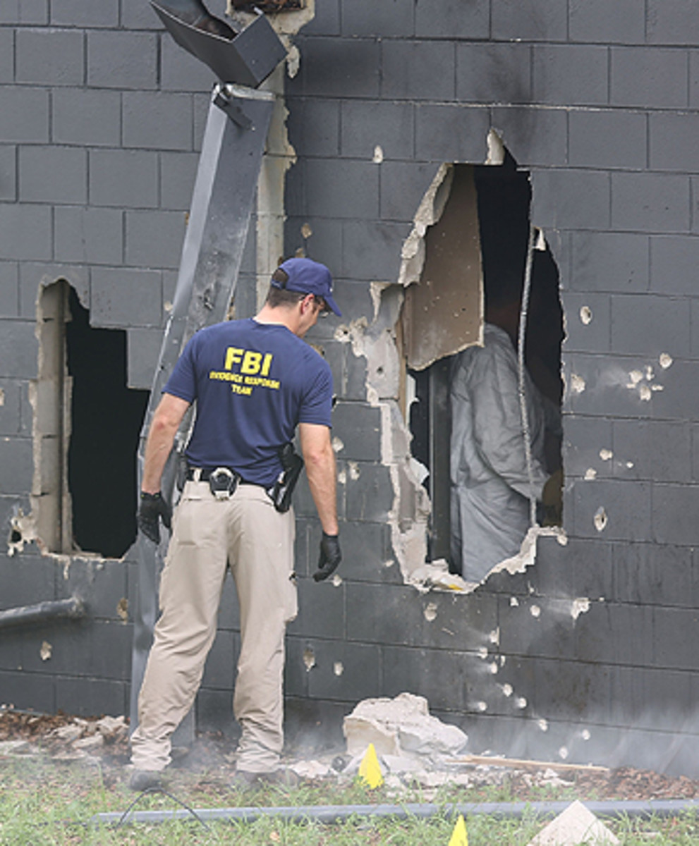 An FBI agent investigates the back wall of Pulse Nightclub in Orlando.