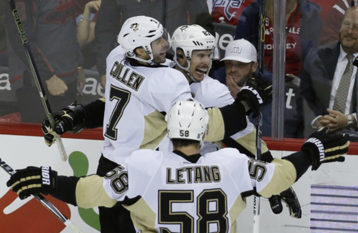 Pittsburgh Penguins centers Matt Cullen (7) and Sidney Crosby (87) celebrate Crosby's winning goal with defenseman Kris Letang (58) after the overtime period of an NHL hockey game against the Washington Capitals, Thursday, April 7, 2016, in Washington. (A