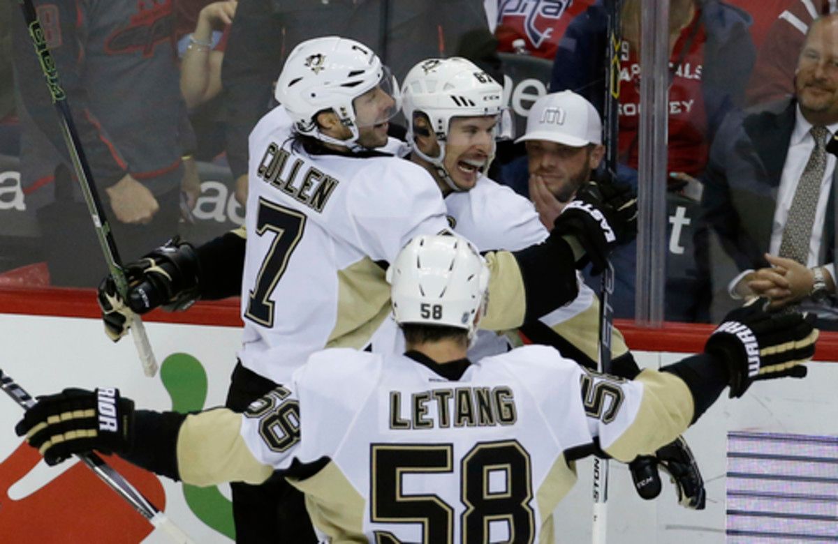 Pittsburgh Penguins centers Matt Cullen (7) and Sidney Crosby (87) celebrate Crosby's winning goal with defenseman Kris Letang (58) after the overtime period of an NHL hockey game against the Washington Capitals, Thursday, April 7, 2016, in Washington. (A