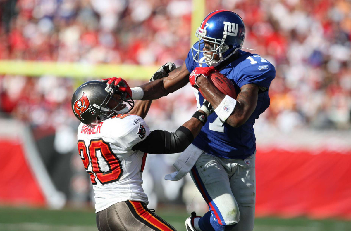 Barber grapples with the Giants’ Plaxico Burress in a 2008 game. 