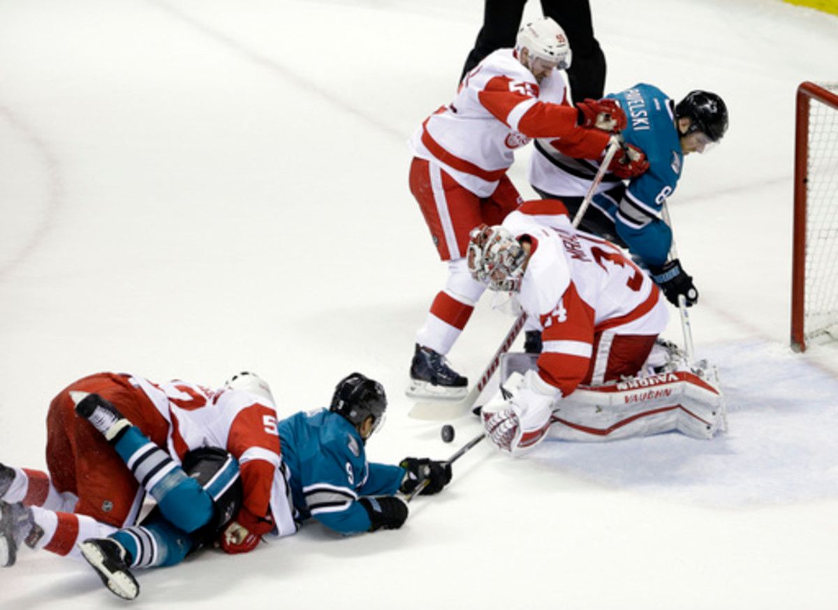 Detroit Red Wings goalie Petr Mrazek, bottom right, stops a shot next to teammate Niklas Kronwall (55) and San Jose Sharks' Joe Pavelski (8) during the first period of an NHL hockey game Thursday, Jan. 7, 2016, in San Jose, Calif. (AP Photo/Marcio Jose Sa