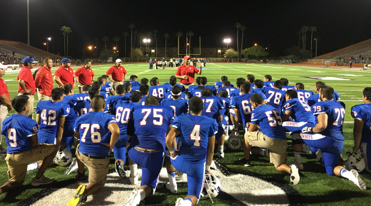 Porter High football players listen to coaching instructions.