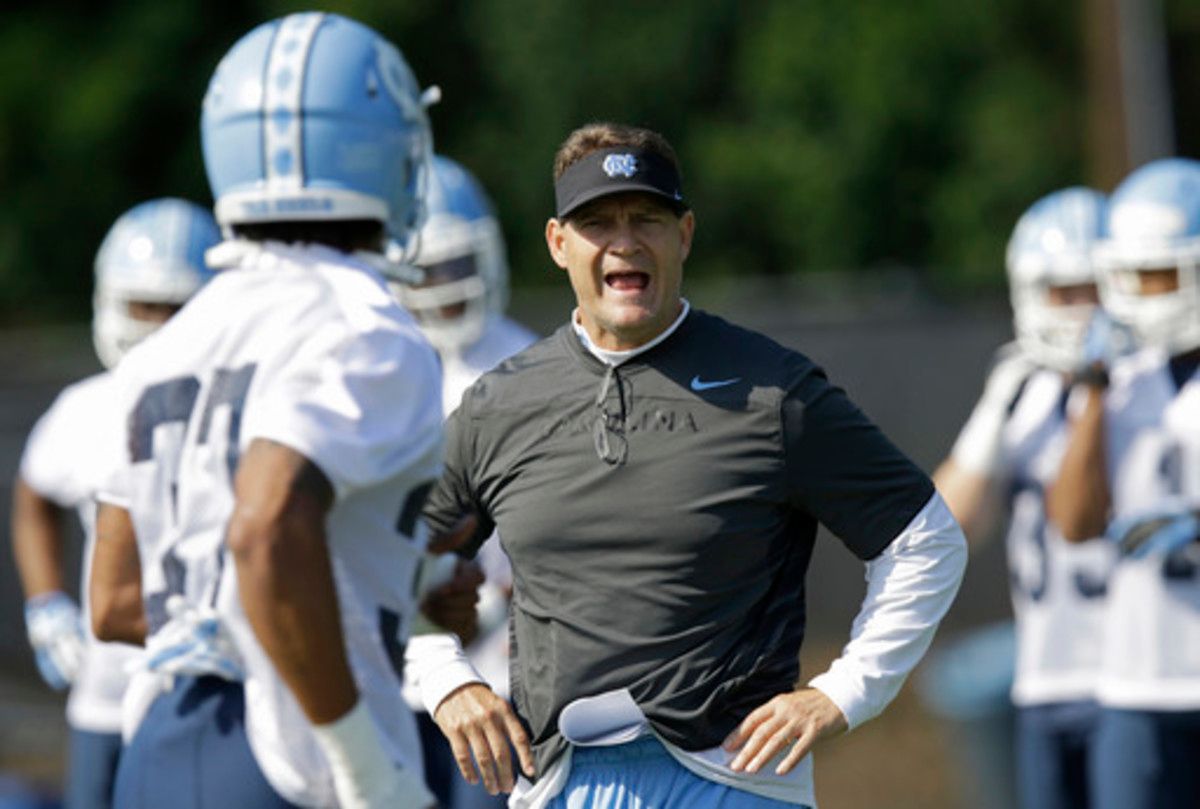FILE - In this Monday, Aug. 3, 2015, file photo, North Carolina defensive coordinator Gene Chizik works with players during the team's first NCAA college football practice of the season in Chapel Hill, N.C. Chizik said the focus for this year's defense is