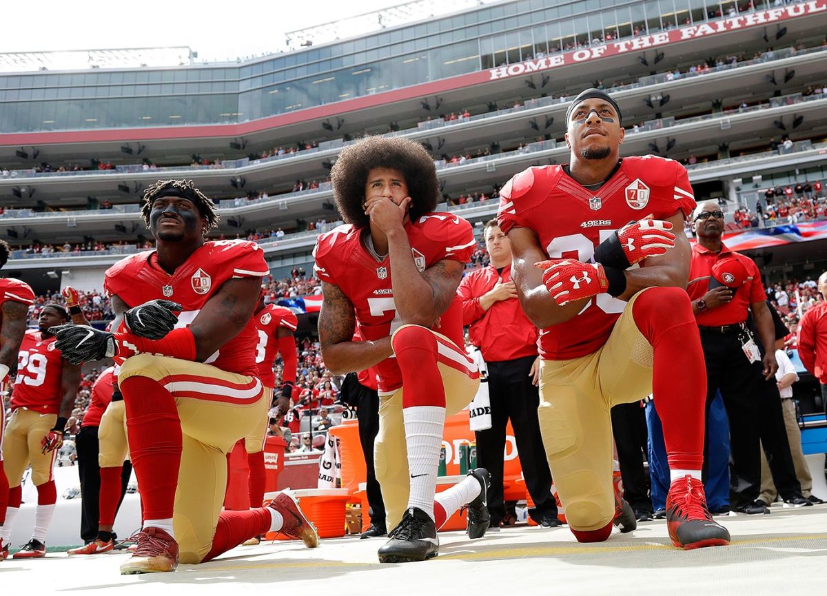 Eli Harold, Colin Kaepernick and Eric Reid kneeling during the national anthem before a San Francisco 49ers game in 2016.