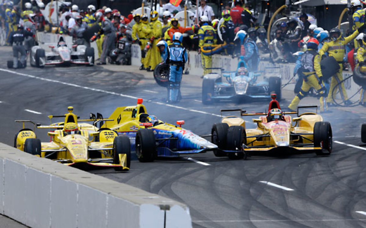 Helio Castroneves, left, Townsend Bell, center, and Ryan Hunter-Reay collide as they exit the pit area.