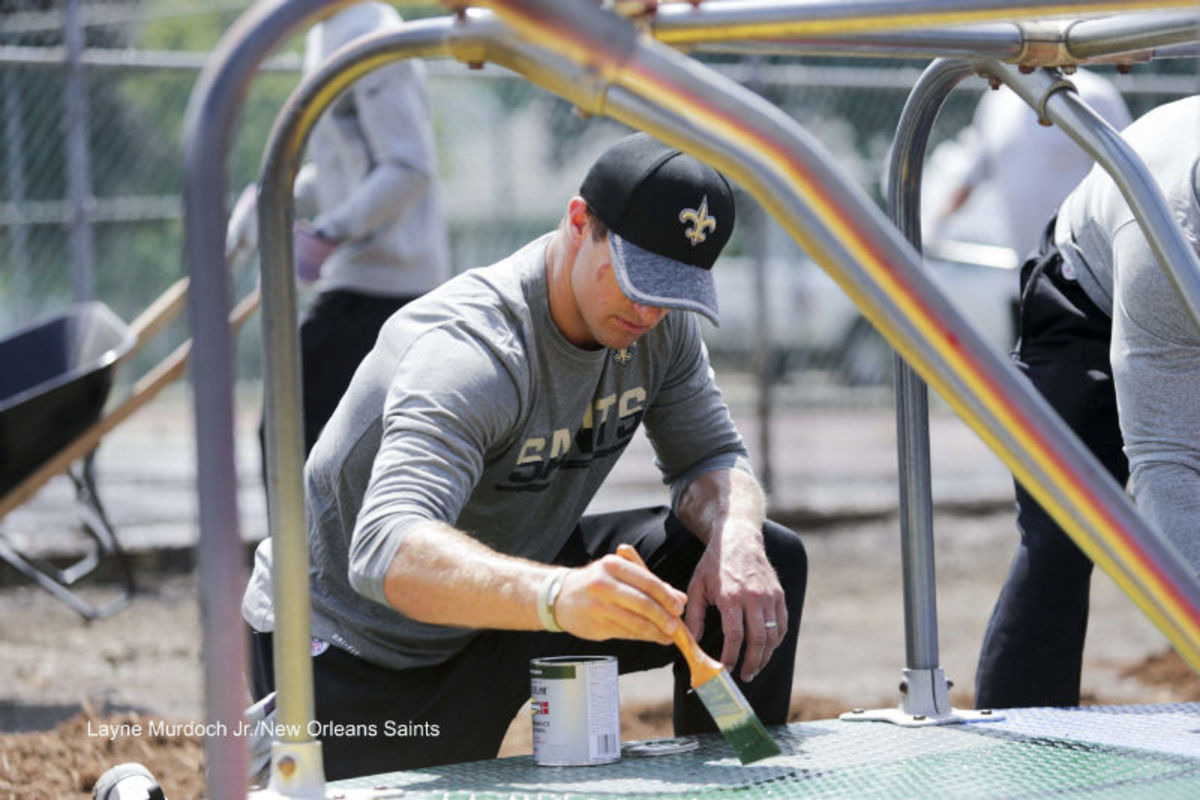 Saints QB Drew Brees paints a merry-go-round in the playground area of Villa Park.