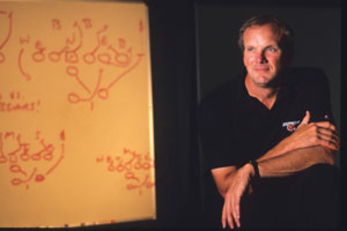 Wyche poses next to a play he drew up for the Bengals in 1989.