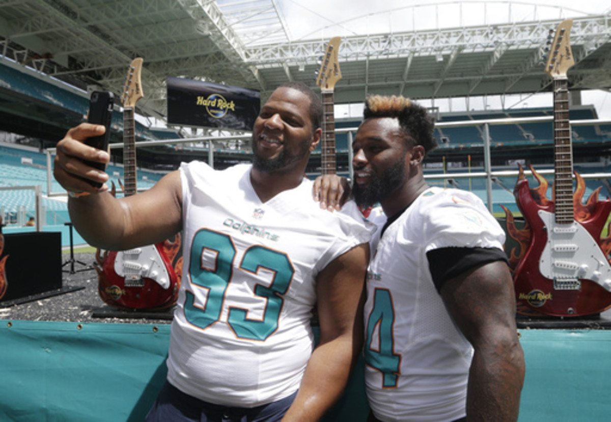 Miami Dolphins defensive tackle Ndamukong Suh (93) and wide receiver Jarvis Landry (14) take a selfie following a ceremony for a stadium naming rights agreement between the Miami Dolphins NFL football team and Hard Rock International, Wednesday, Aug. 17, 
