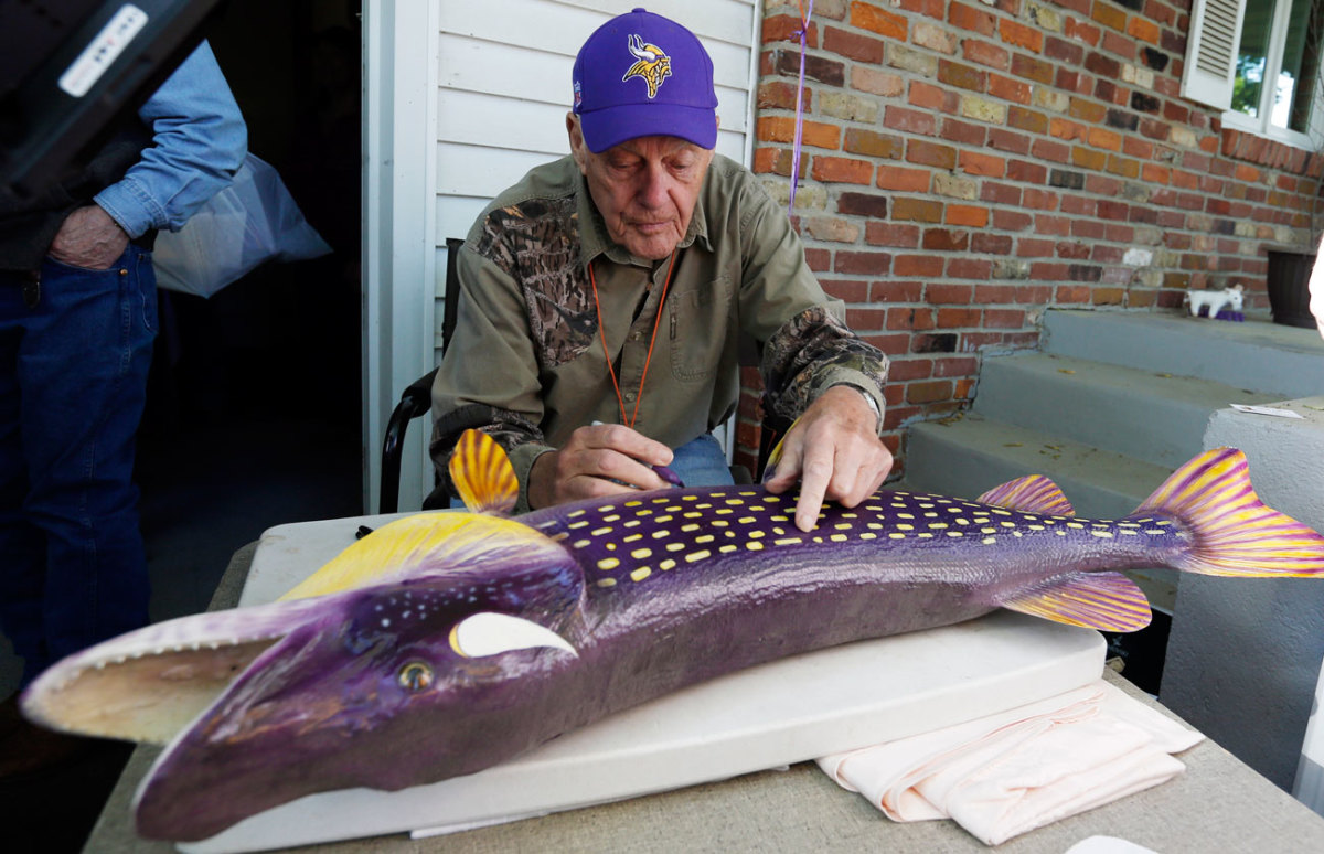 At one of his yard sales, Grant signs a piece of piscatory memorabilia for a fan.