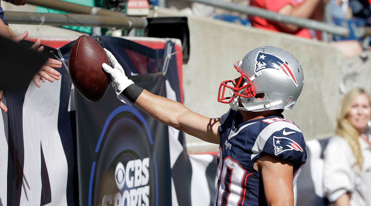 Danny Amendola hands a fan the football ... that happened to be used for Tom Brady's 400th career touchdown pass. (Steven Senne/AP)