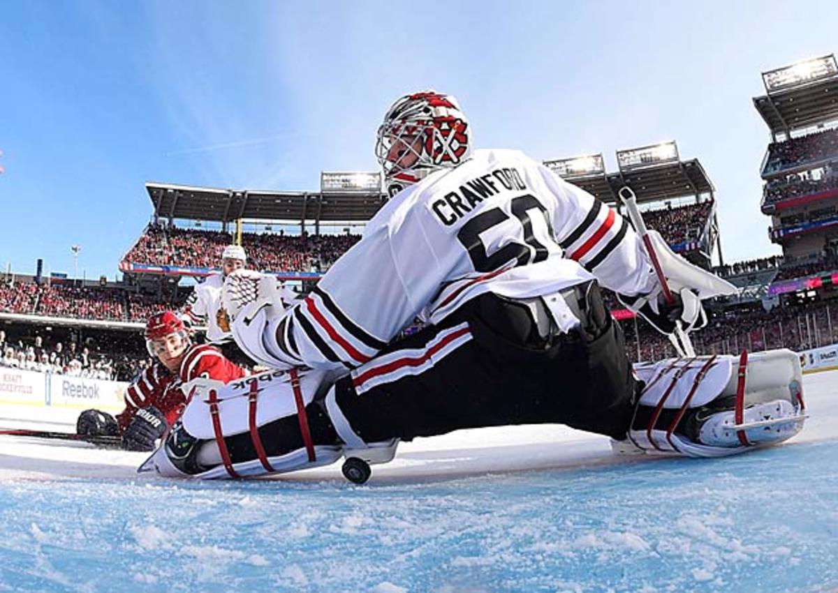 Blackhawks goalie Corey Crawford looks for the puck after stopping a shot.