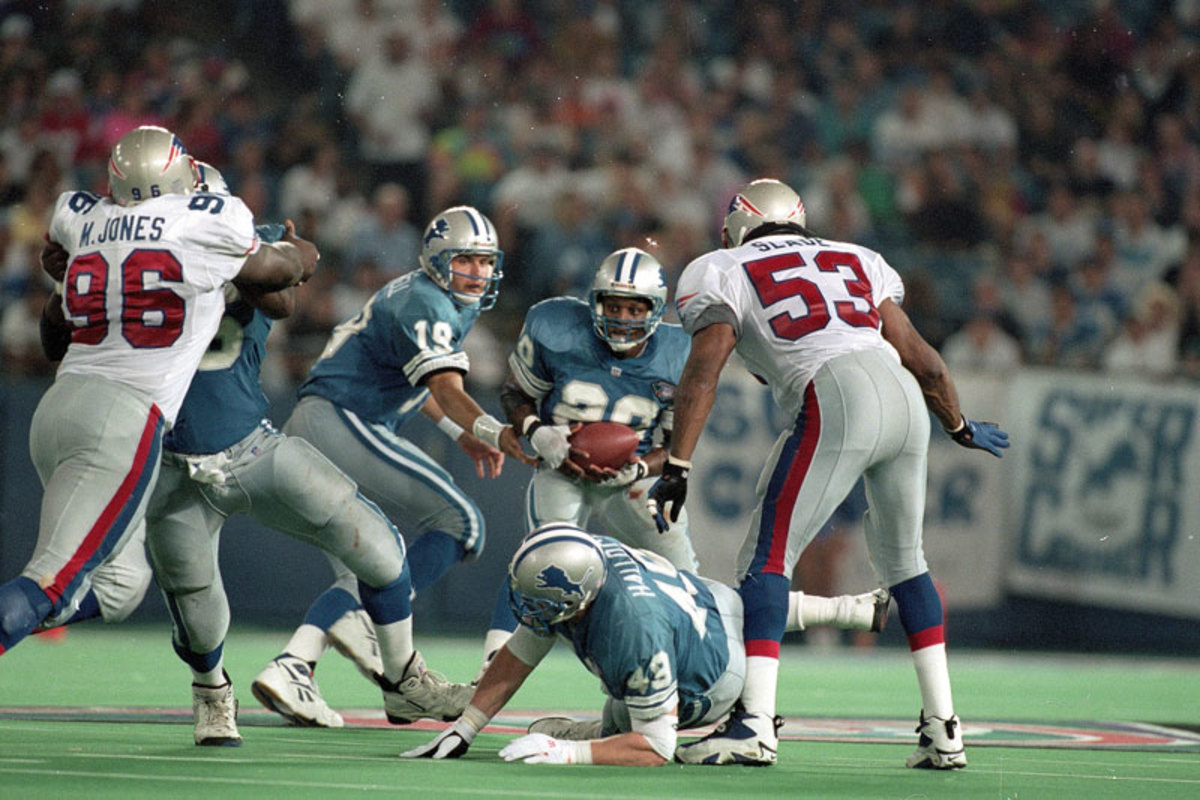 Lions running back Scott Mitchell hands the ball off to running back Barry Sanders.