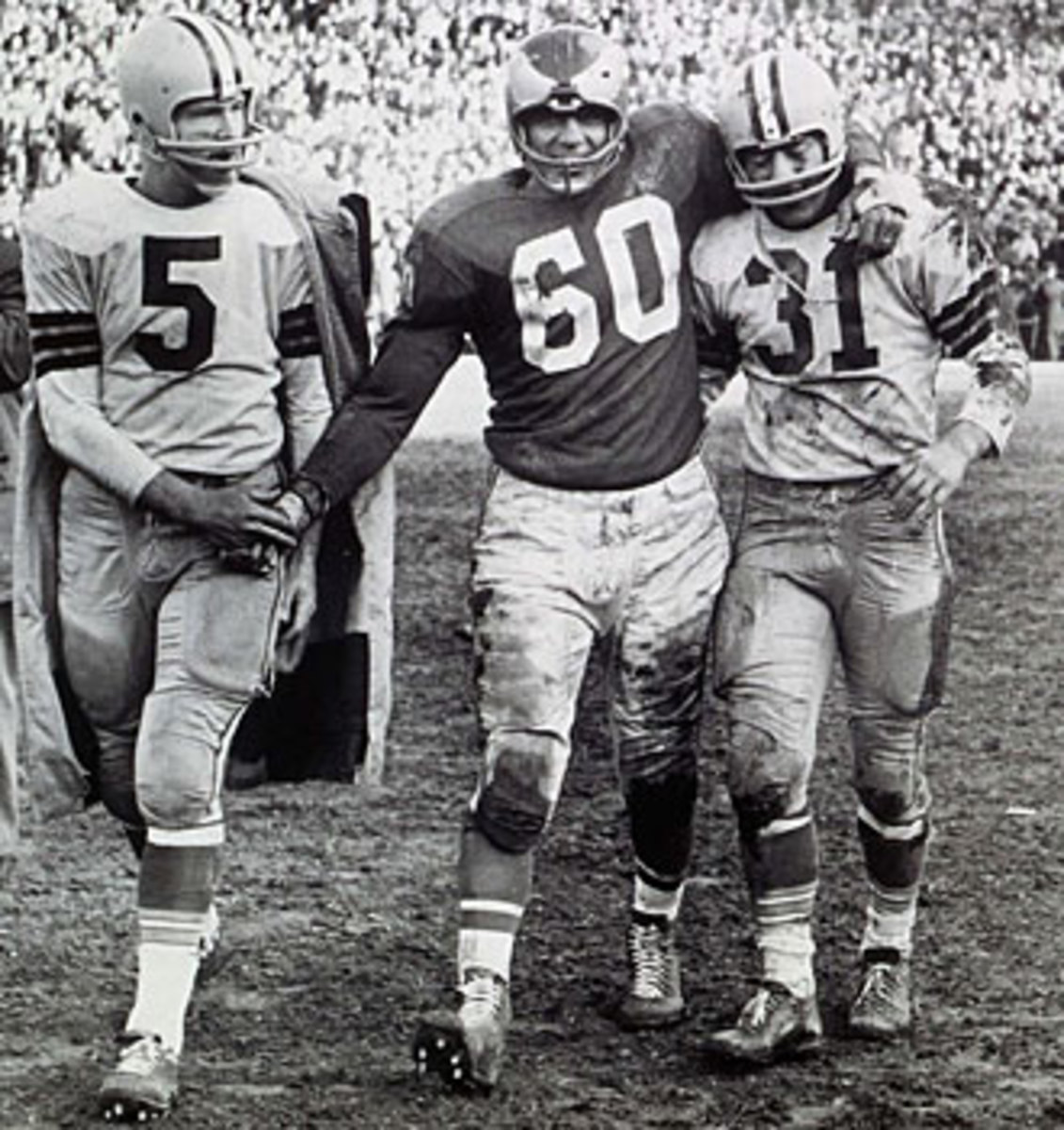 After nailing down the 1960 NFL title, Bednarik consoled Green Bay's Paul Hornung (left) and Jim Taylor.