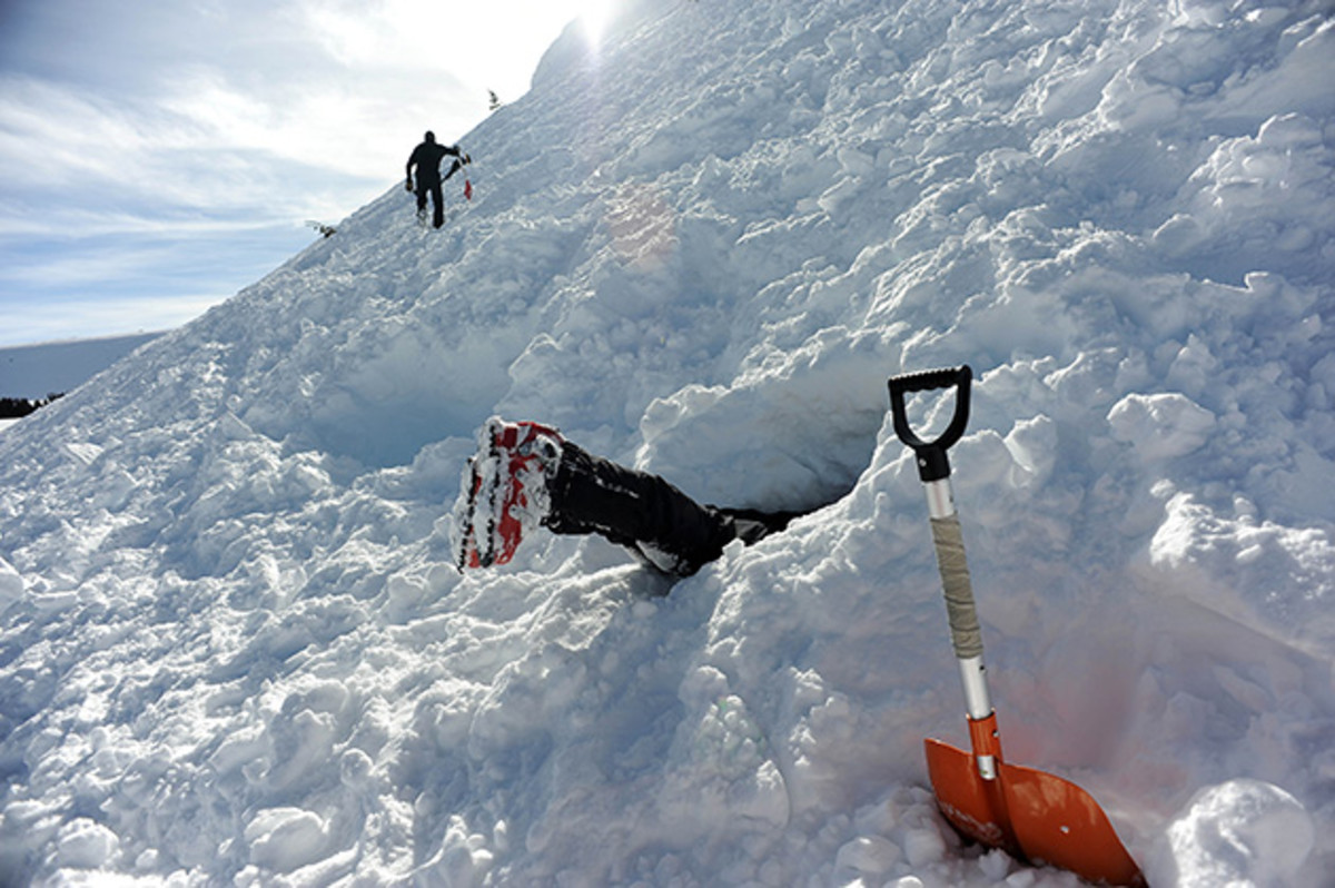 Breckenridge Ski Patroller Hunter Mortensen clears snow out of a pit where people will be buried to act as live victims for a dog rescuer training exercise as part of the Avalanche Deployment program at Vail Pass.