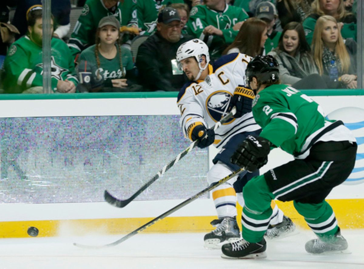 Buffalo Sabres right wing Brian Gionta (12) takes a shot at the net as Dallas Stars' Jyrki Jokipakka (2) of Finland defends in the second period of an NHL hockey game, Saturday, Nov. 21, 2015, in Dallas. (AP Photo/Tony Gutierrez)
