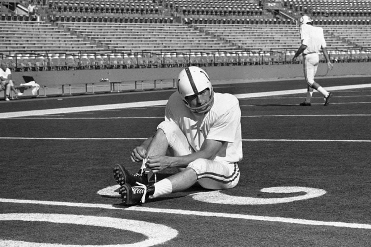 Unitas laces ups his high-tops—this pair specially designed for the Orange Bowl’s artificial turf—before Super Bowl V. (William Smith/AP)