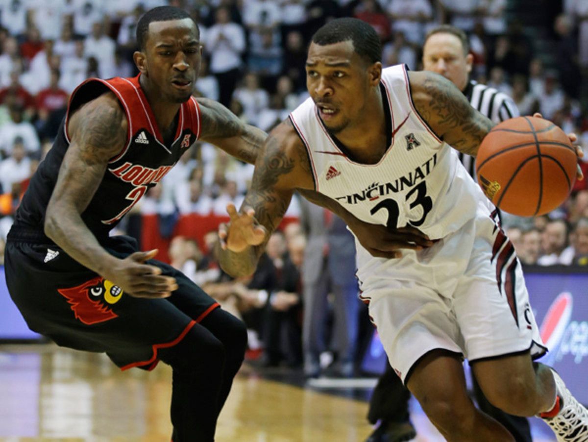 Russ Smith (left) and Louisville squeaked by Sean Kilpatrick and Cincinnati late. (Al Behrman/AP)