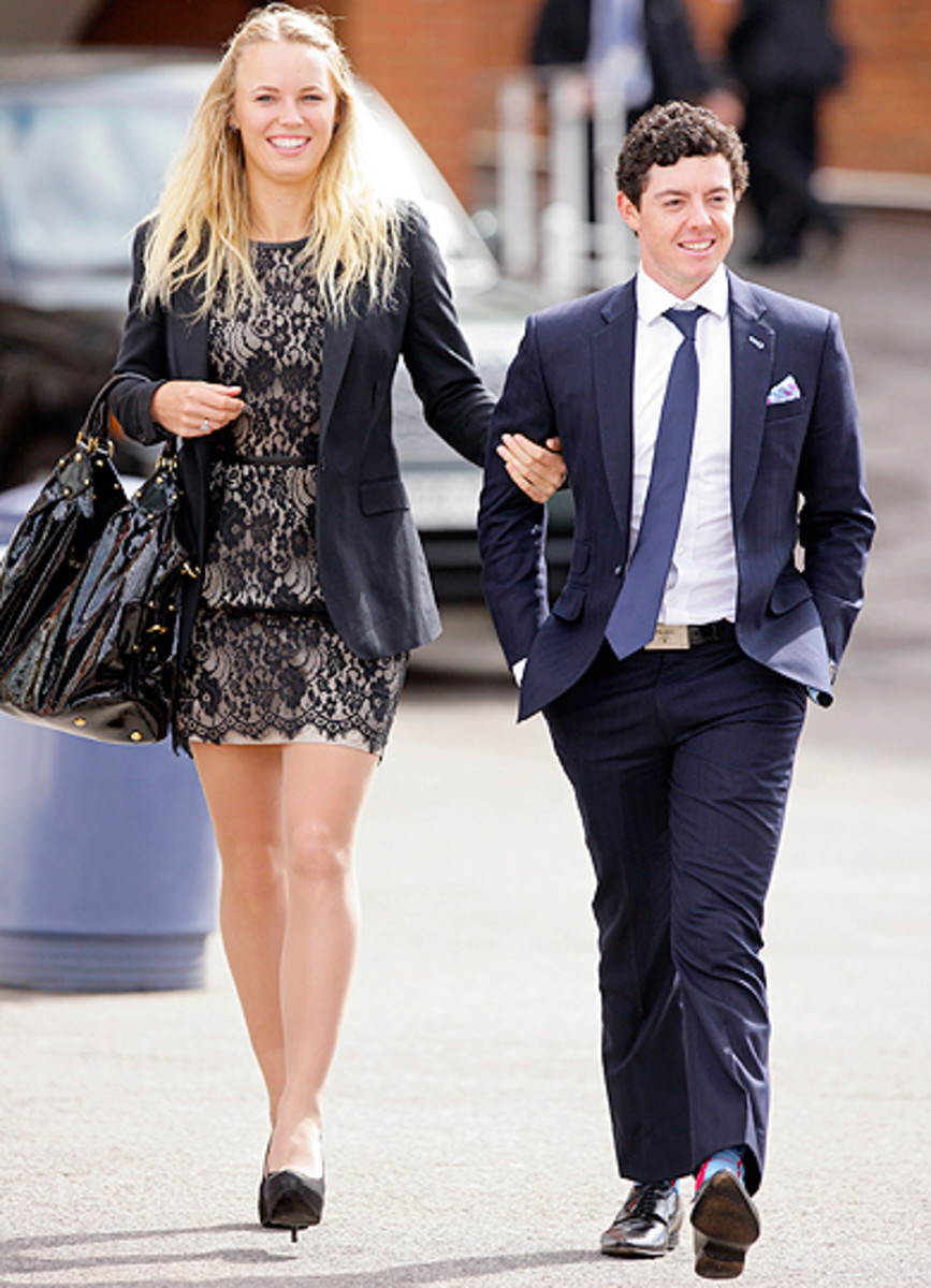 Caroline Wozniacki and golfer Rory McIlroy walk arm-in-arm.