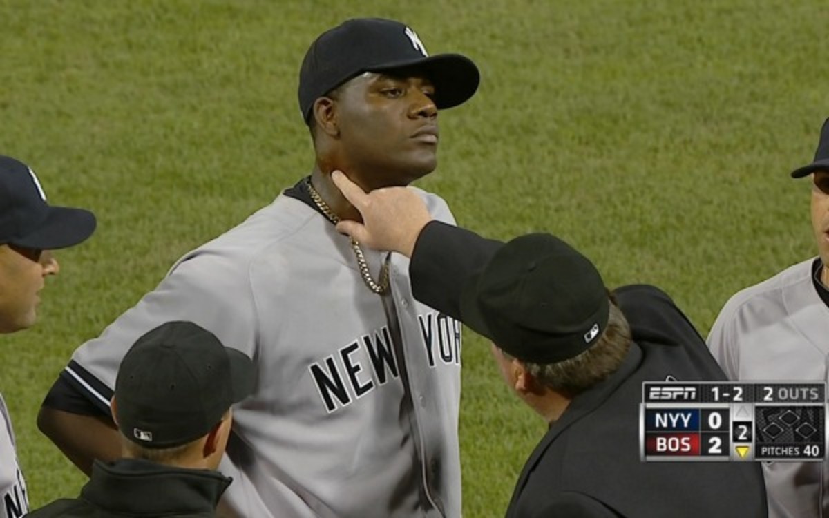 In this April 23, 2014 photo taken from video and provided by ESPN, home plate umpire Gerry Davis touches the neck of New York Yankees starting pitcher Michael Pineda in the second inning of the Yankees' baseball game against the Boston Red Sox at Fenway Park in Boston. Pineda was ejected after umpires found a foreign substance on his neck. (AP Photo/ESPN)