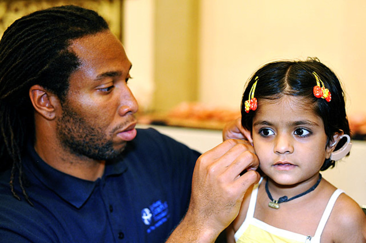 larry-fitzgerald-india-2010-inserting-hearing-aid.jpg