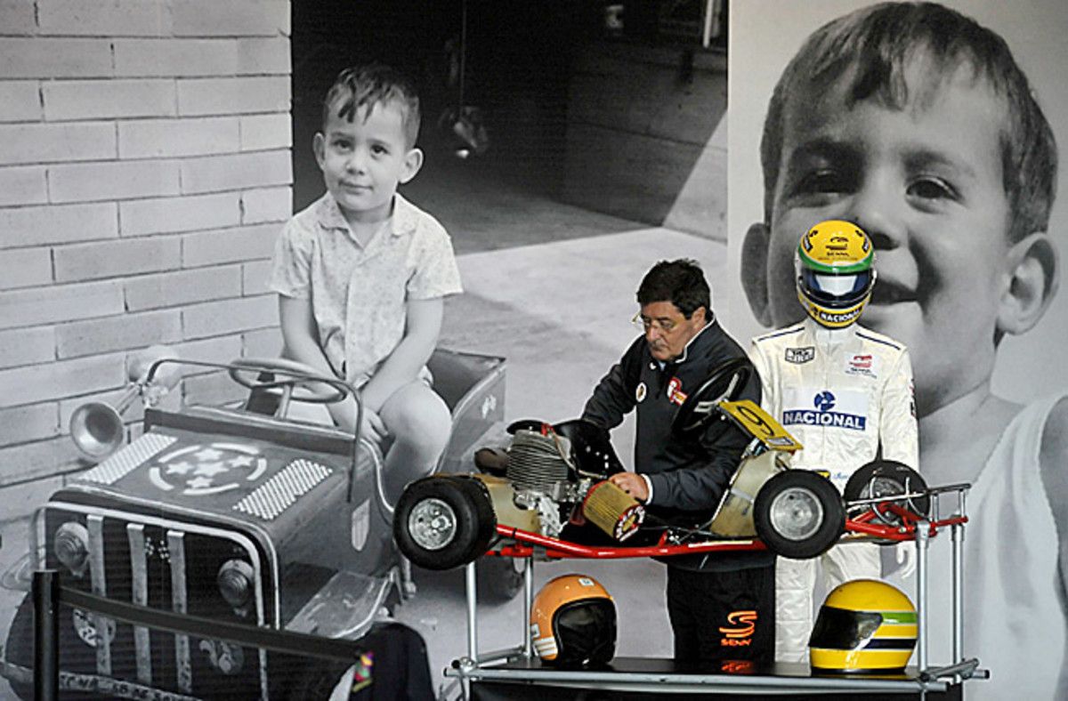 A fan at the track in Imola, Italy is framed by pictures of late F1 driver Ayrton Senna as a boy.