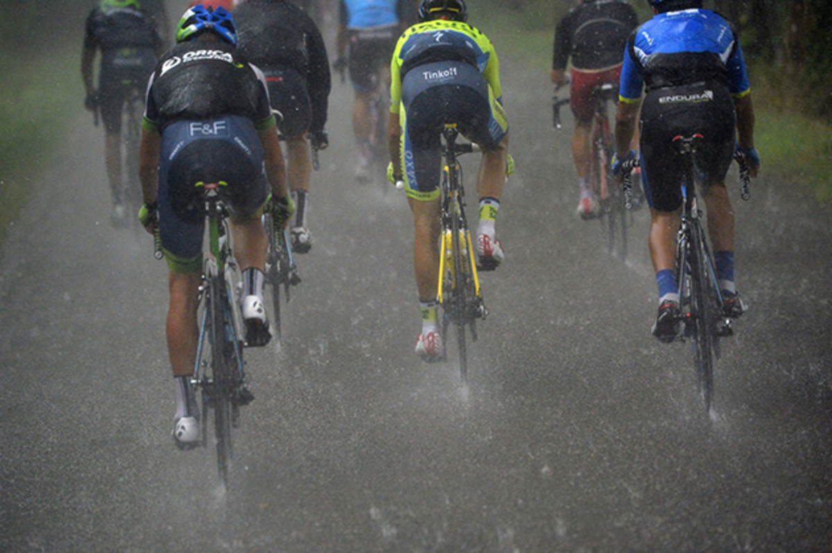 Cyclists ride under a heavy rain during the 208.5 km nineteenth stage of the Tour de France cycling race.