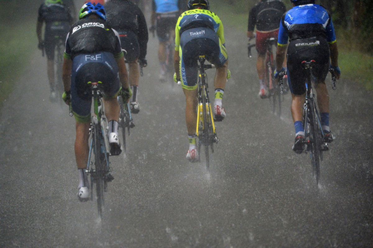 Cyclists ride under a heavy rain during the 208.5 km nineteenth stage of the Tour de France cycling race.