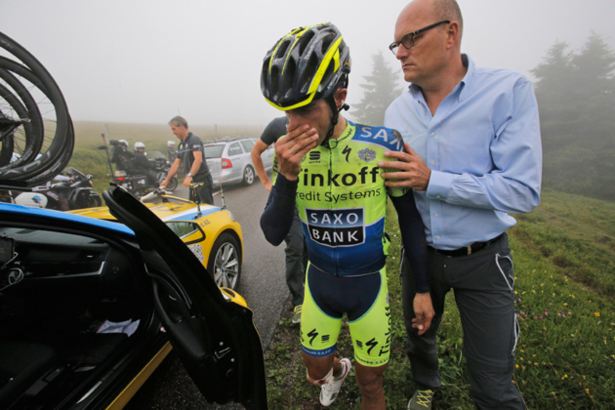 Spain's Alberto Contador abandons the race after crashing during the tenth stage of the Tour de France cycling race over 161.5 kilometers (100.4 miles) with start in Mulhouse and finish in La Planche des Belles Filles, France, Monday, July 14, 2014. At right is team manager Bjarne Riis of Denmark.