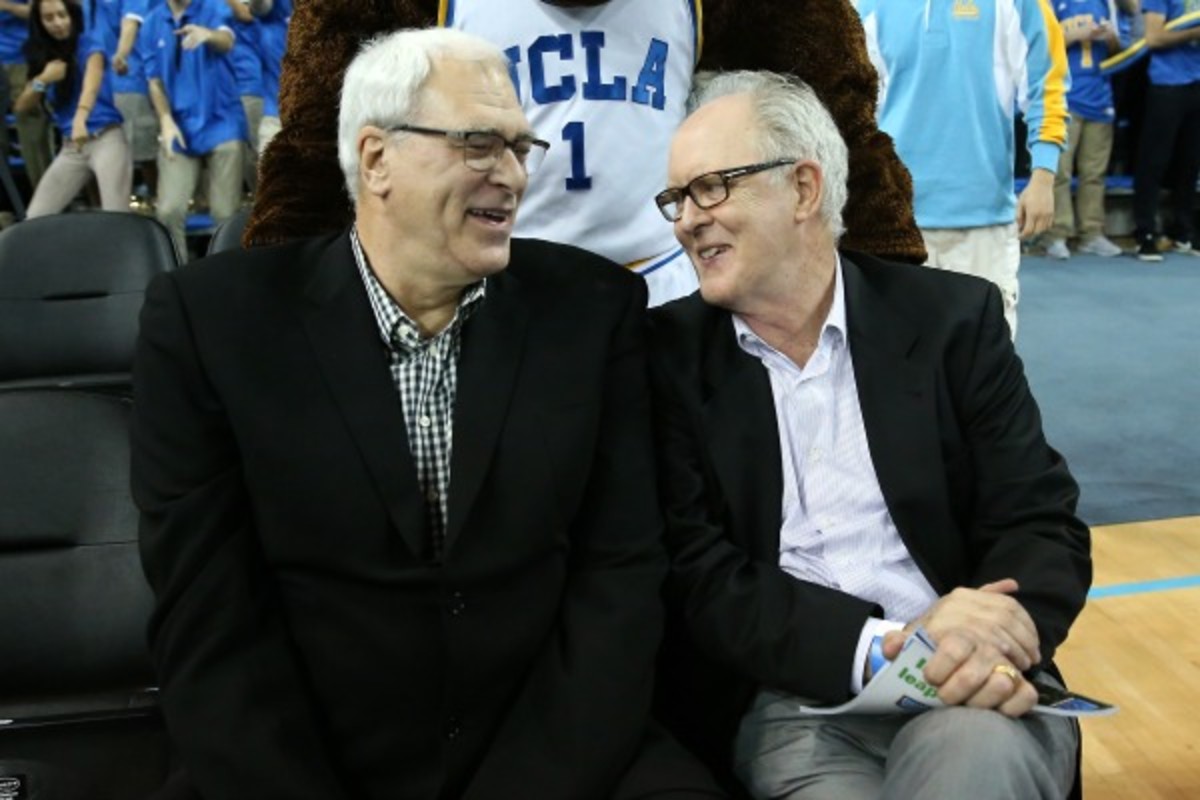 Phil Jackson (left) took in a recent UCLA game with actor John Lithgow. (Stephen Dunn/Getty Images)