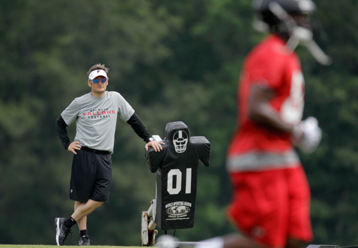 Atlanta Falcons GM Thomas Dimitroff, left, looks on during a football practice.