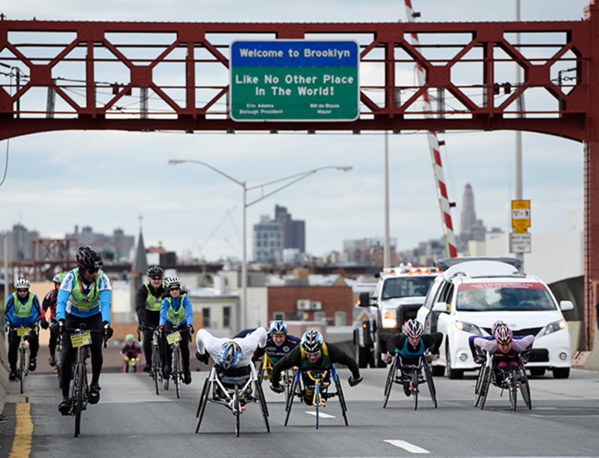 Wheelchair competitors accompanied by cyclists cross the Pulaski Bridge to enter the Queens borough of New York during the New York City Marathon.