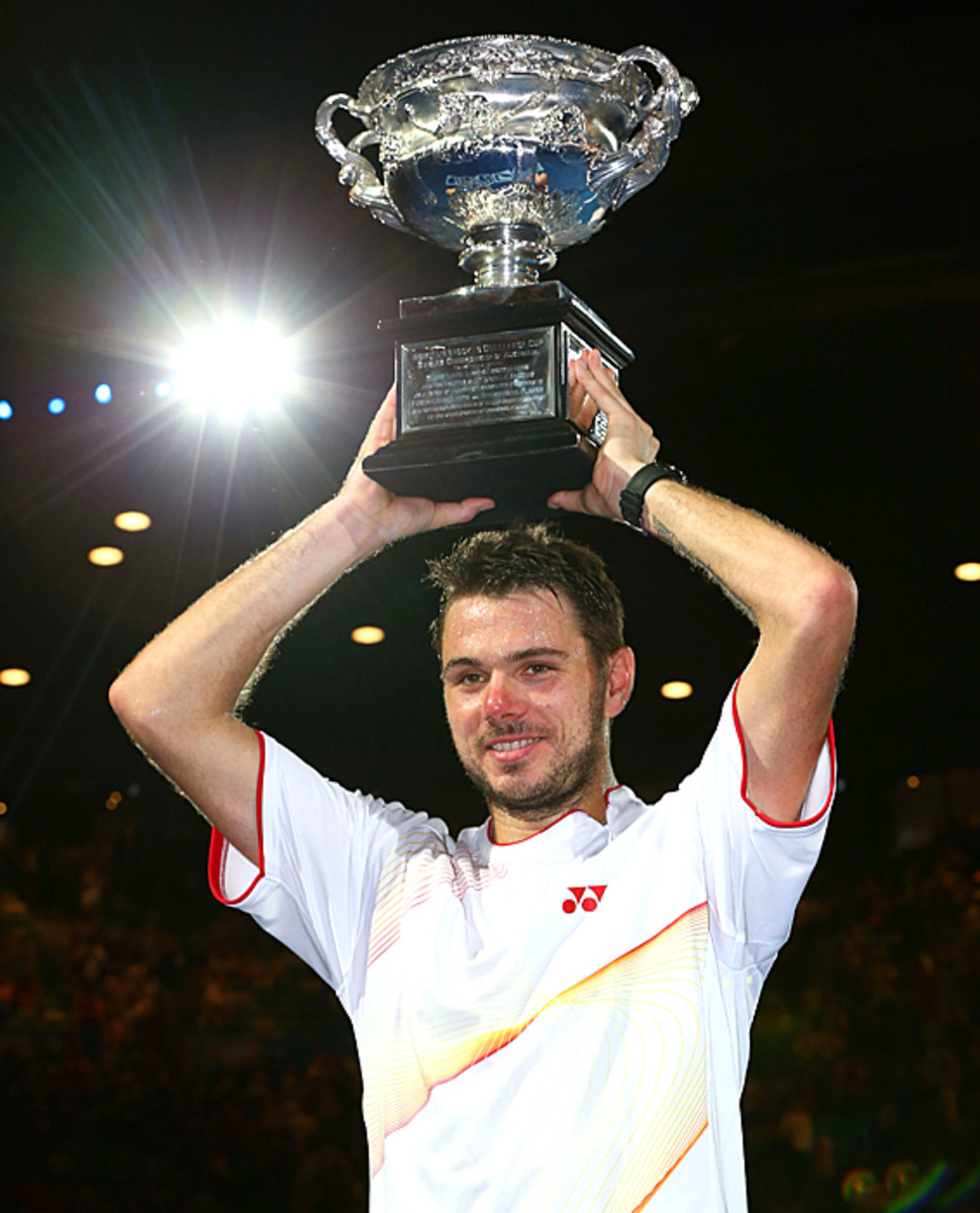 Stanislas Wawrinka hoists the trophy after winning his first Grand Slam. (Quinn Rooney/Getty Images)