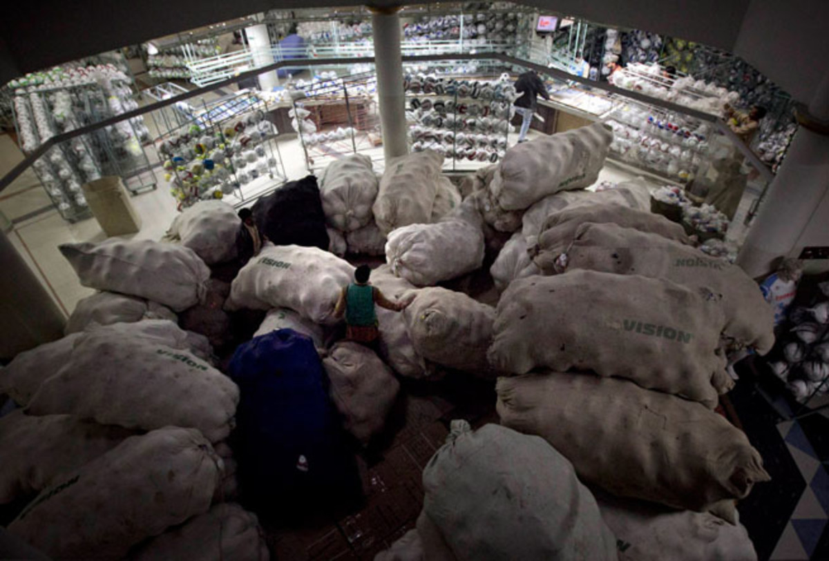 Workers at a factory in Sialkot, Pakistan, pack soccer balls into sacks before they are dispatched for sale.