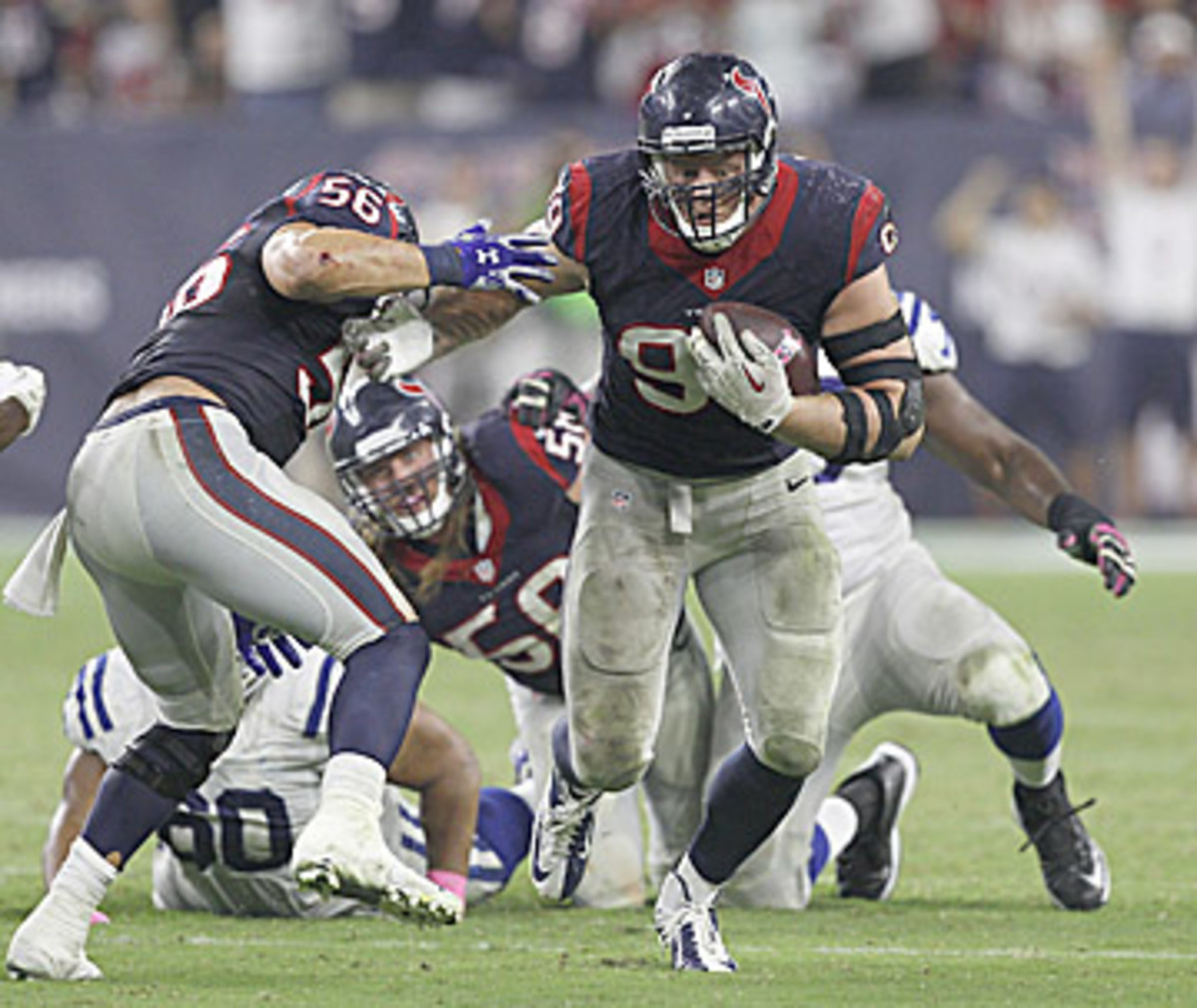 JJ Watt dominated again on Thursday night, including this scoop-and-score for his third touchdown of the year. (Bob Levey/Getty Images)