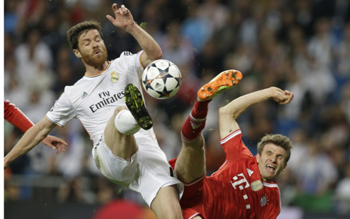 Real's Xabi Alonso and Bayern's Thomas Mueller battle for the ball during the Champions League semifinal. (AP Photo/Paul White)