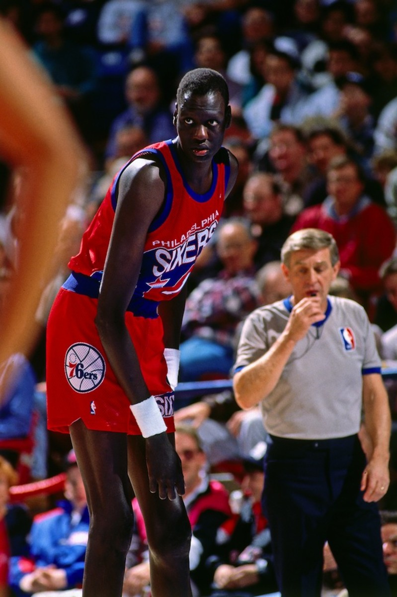 Manute Bol #10 of the Philadelphia 76ers rests against the Sacramento Kings during a game played on January 2, 1992 at Arco Arena in Sacramento, California. 