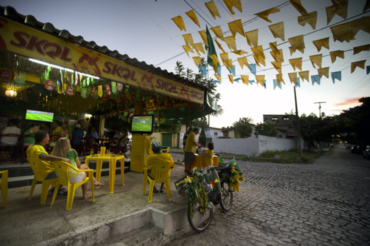 Local patrons and families surround the television sets in a local bar, leaving the streets empty. 