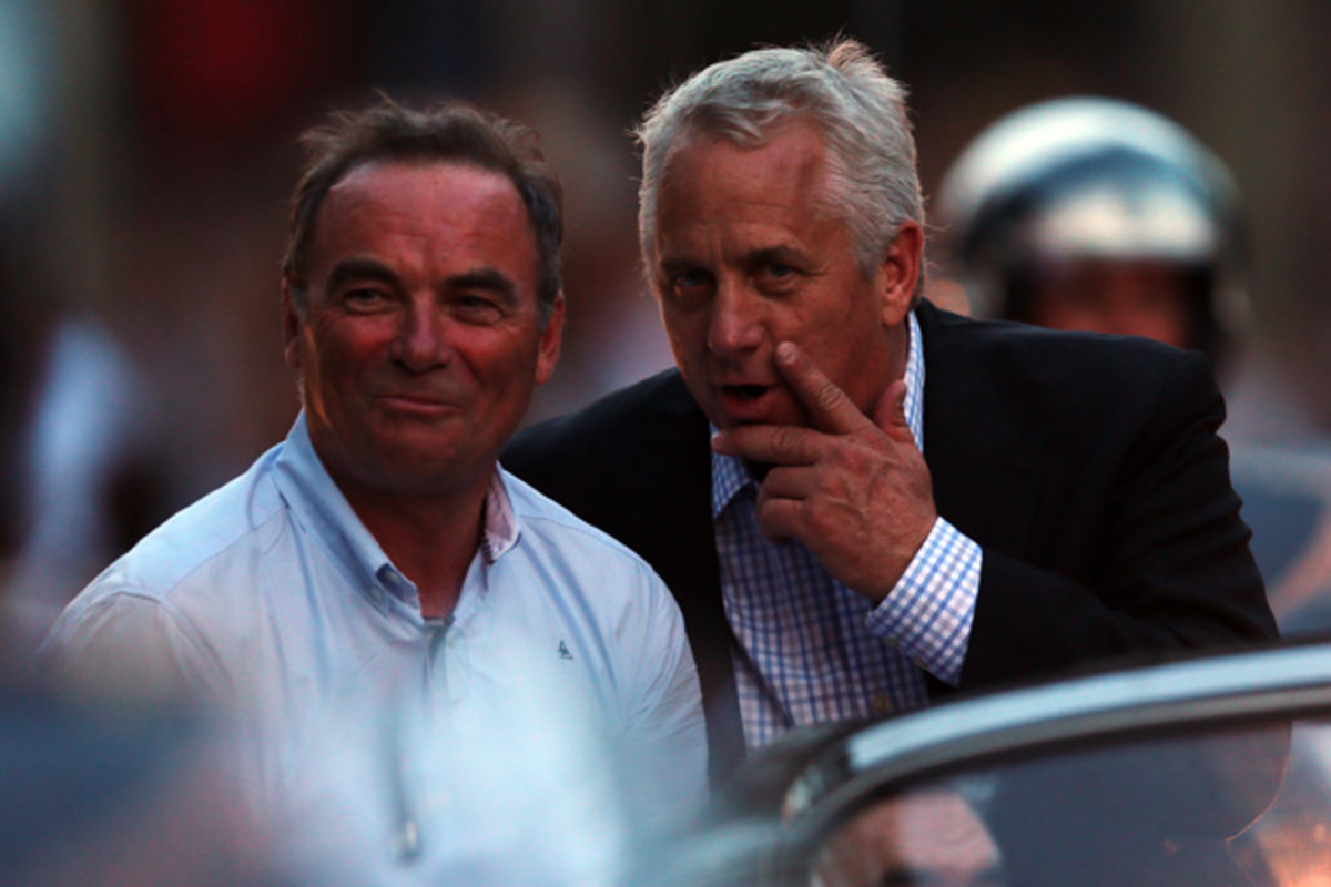 Former Tour winner Bernard Hinault (L) and Greg LeMond share a joke after the twenty first and final stage of the 2013 Tour de France.