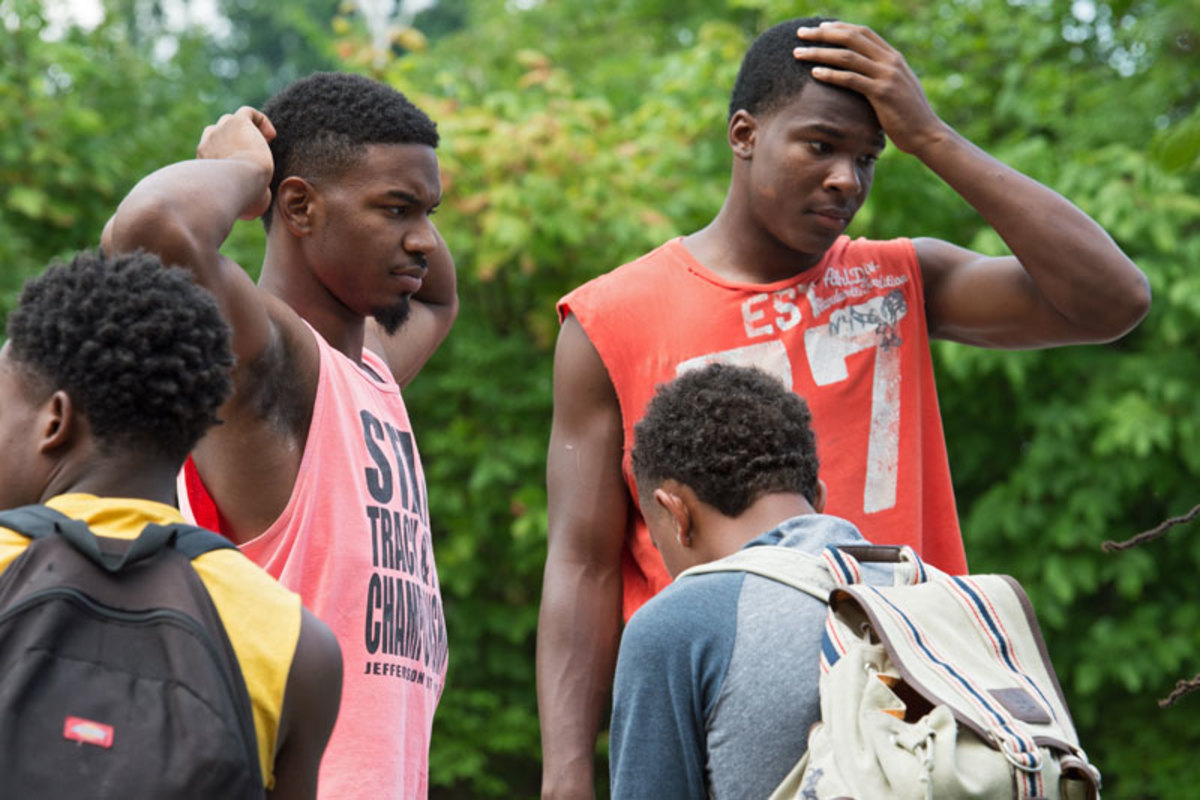 Raequan Stallings (left) and RANDALL CAESER wait for the bus to arrive at McCluer High to take them to practice.  