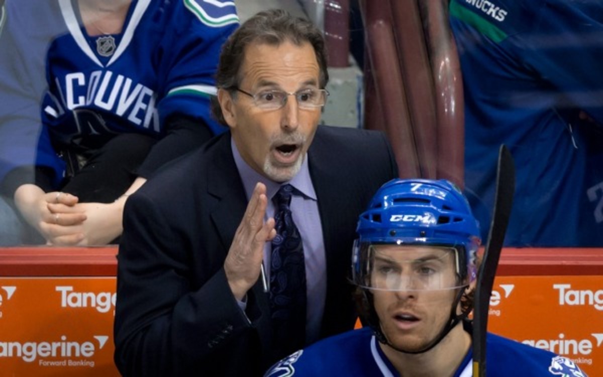 Vancouver Canucks' coach John Tortorella gives instructions to Ryan Kesler, not pictured, as David Booth sits on the bench during the third period of an NHL hockey game against the Colorado Avalanche on Thursday, April 10, 2014, in Vancouver, British Columbia. (AP Photo/The Canadian Press, Darryl Dyck)