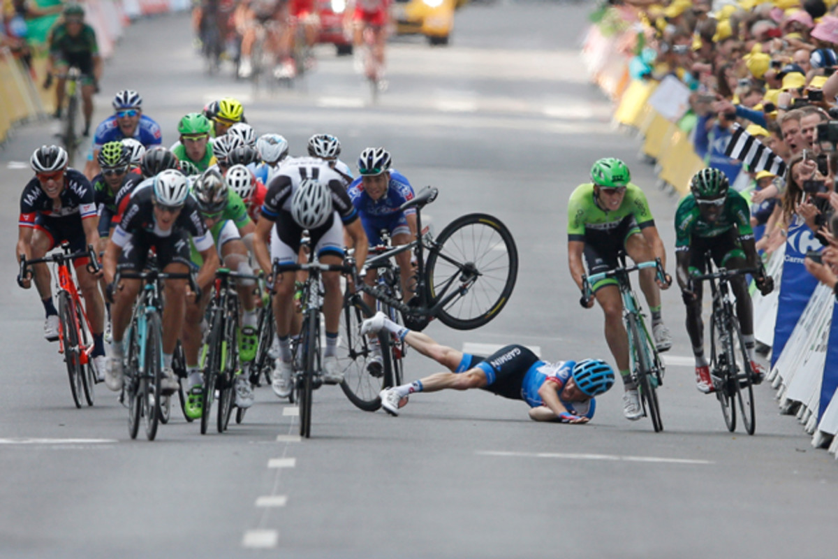 Andrew Talansky of the U.S. crashes as the pack with stage winner Italy's Matteo Trentin, foreground left, sprints towards the finish line during the seventh stage of the Tour de France cycling race over 234.5 kilometers (145.7 miles) with start in Epernay and finish in Nancy, France, Friday, July 11, 2014.