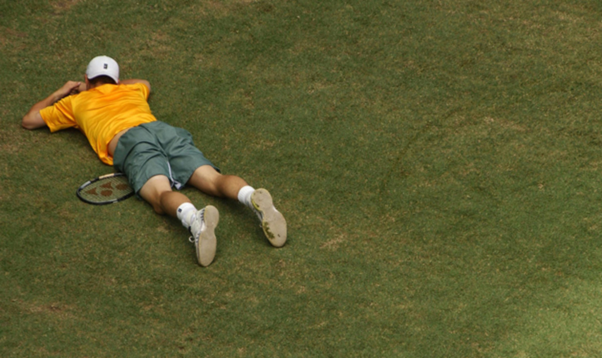 Hewitt of Australia falls to the ground in his match against Escude.