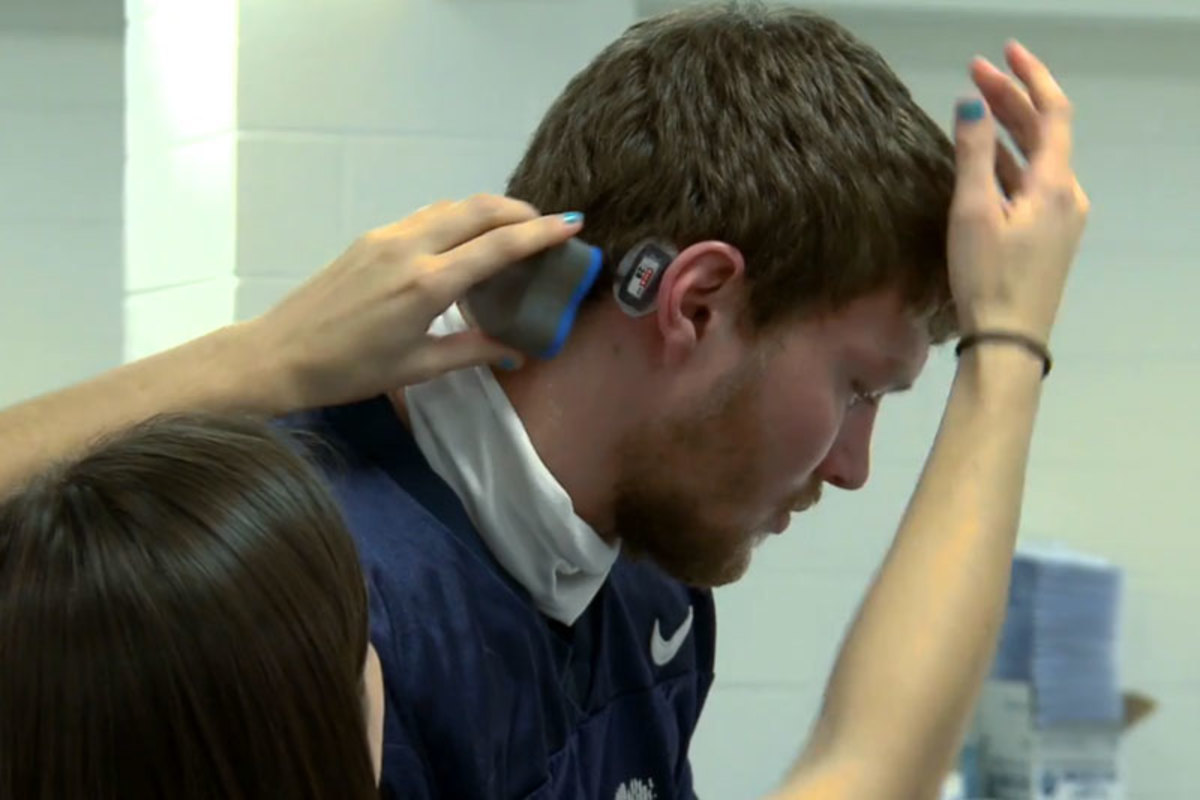 A UNH player is fitted with a sensor before practice. 