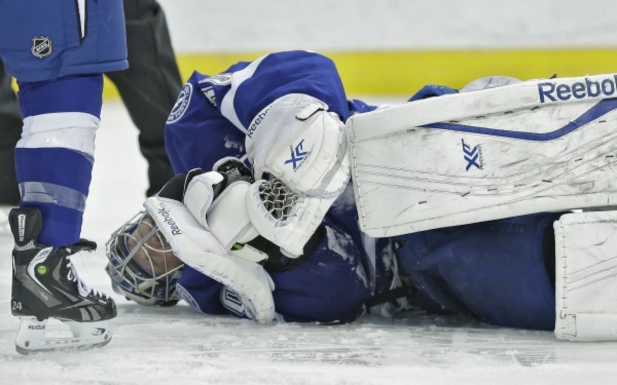 Tampa Bay Lightning goalie Ben Bishop rolls on the ice after injuring his shoulder against the Toronto Maple Leafs during the first period of an NHL hockey game Tuesday, April 8, 2014, in Tampa, Fla. (AP Photo/Chris O'Meara)