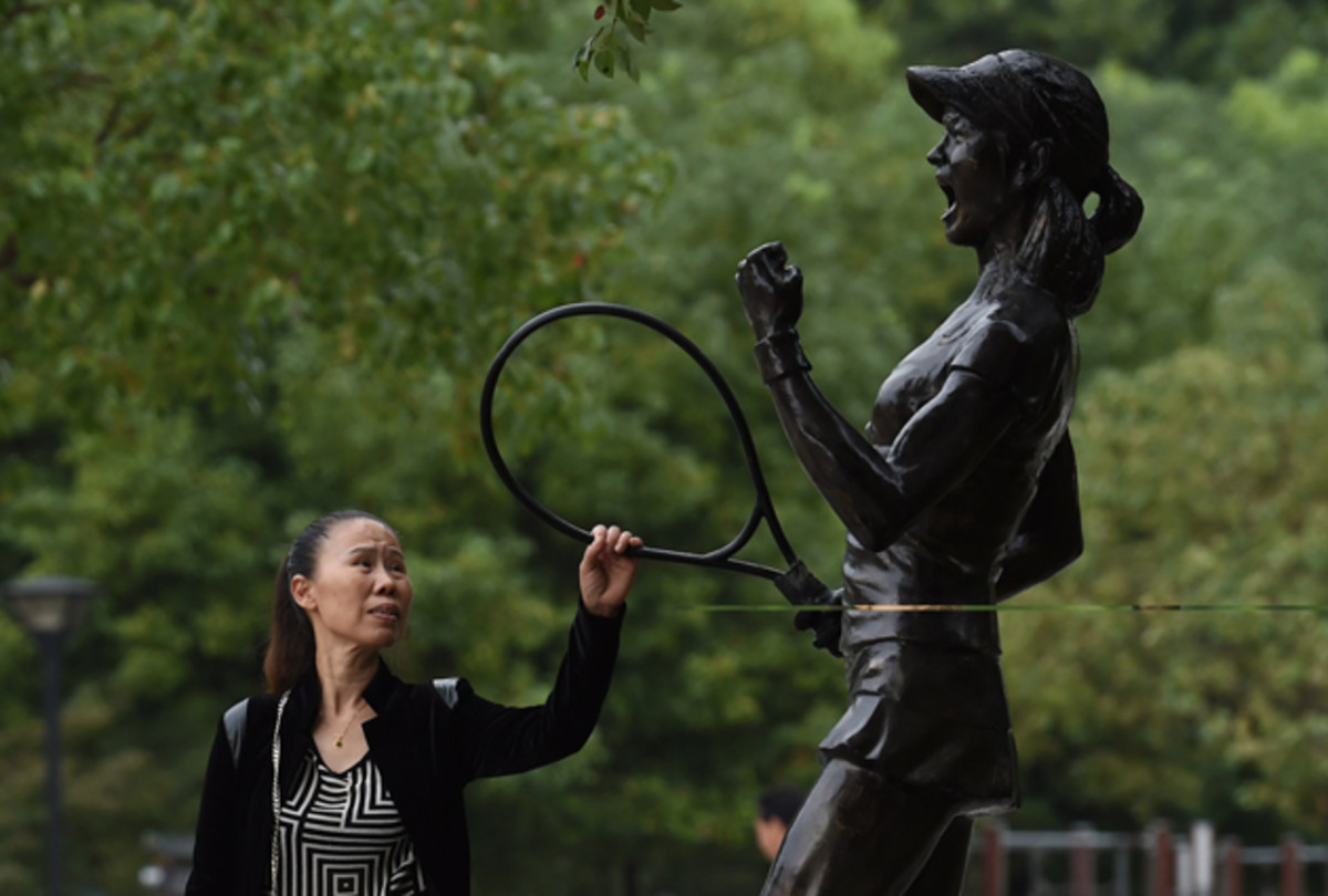 A woman reaches out to touch a statue of Chinese tennis star Li Na at a park in Wuhan, her hometown, in China's Hubei province.