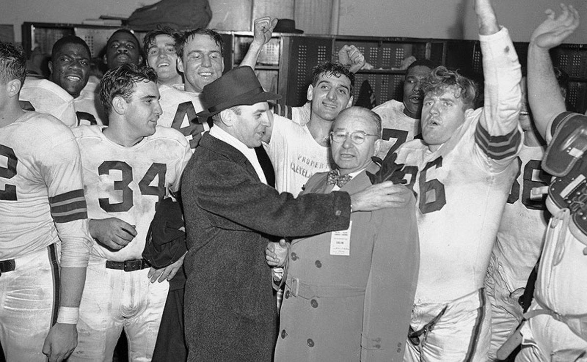 Paul Brown (left) and owner Mickey McBride celebrate with the team after the Browns won their second straight AAFC title in December 1947. (AP)