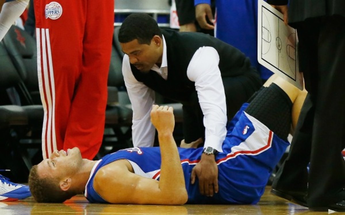 Trainer Jasen Powell looked at Griffin in the first half of Saturday night's game after Griffin exited with lower back spasms. (Scott Halleran/Getty Images)