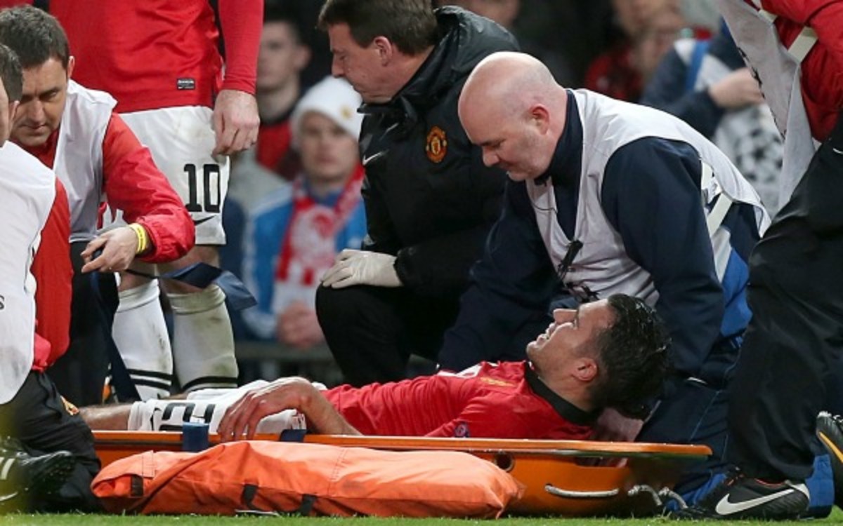 Man U's striker Robin van Persie is carted off after a knee injury. (Peter Byrne/PA Wire, Press Association via AP Images)