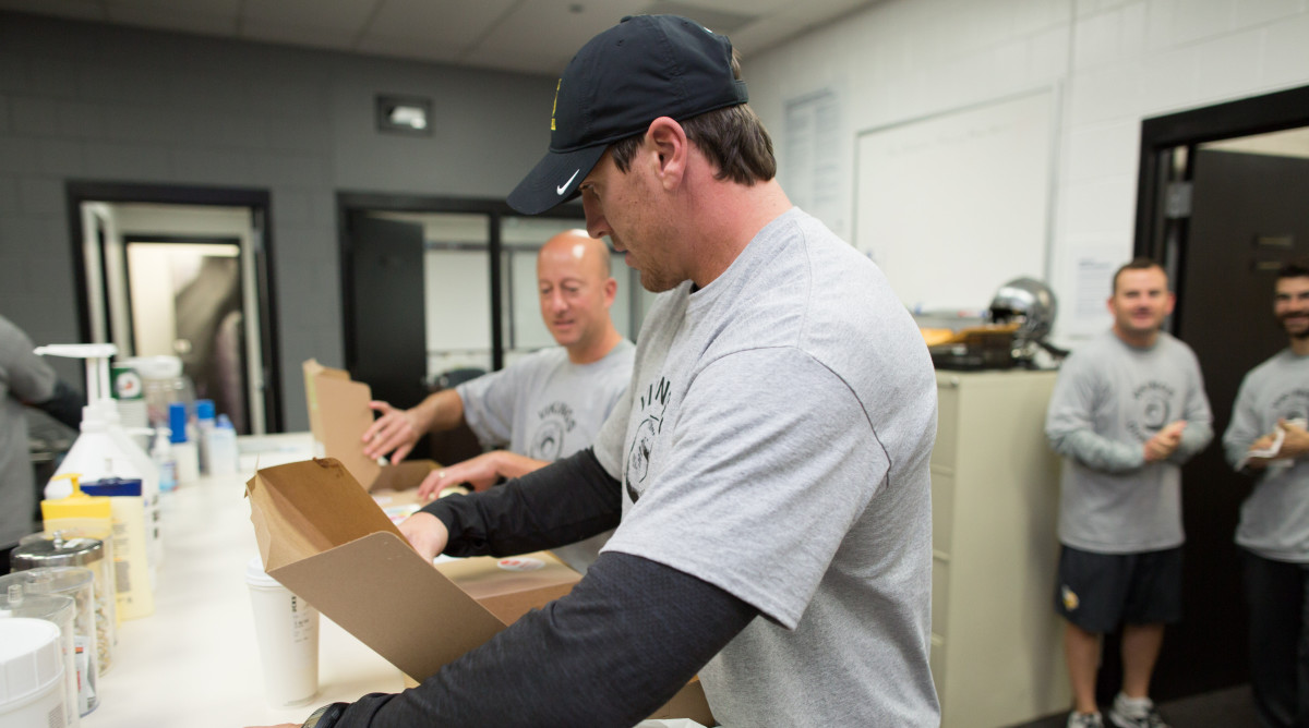 Donut Club president Eric Sugarman and board member Chad Greenway open the boxes to begin the viewing period.